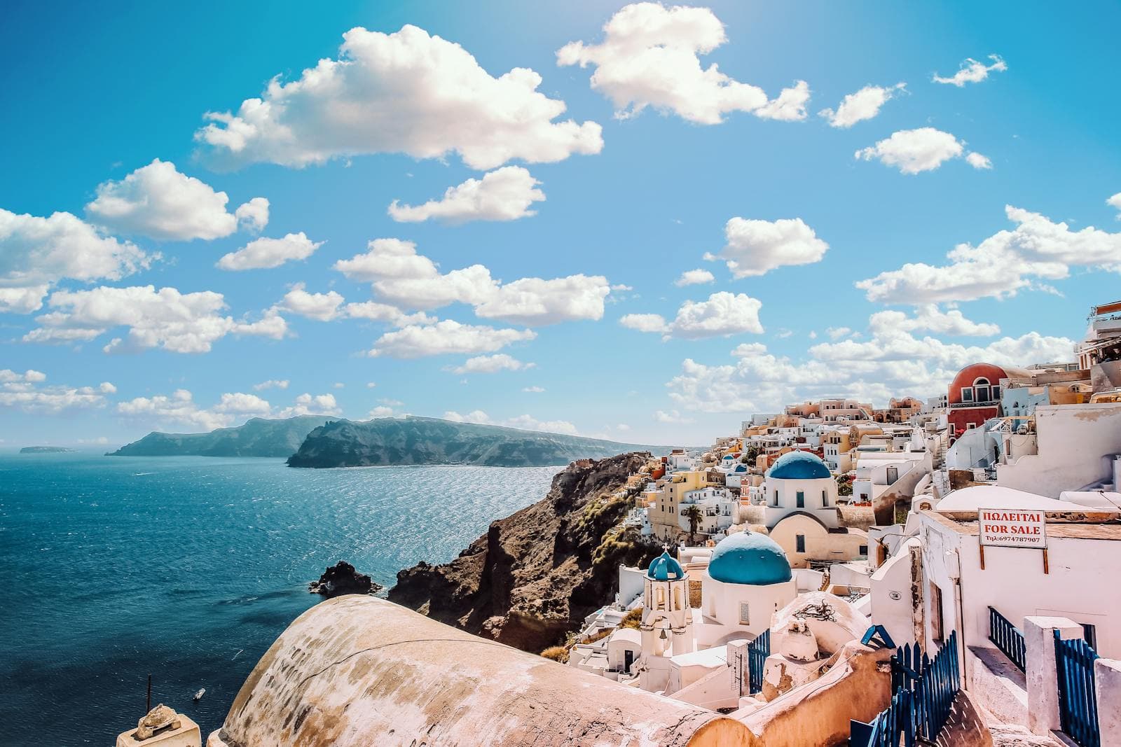 Santorini caldera view at sunset with white church dome and deep blue Aegean